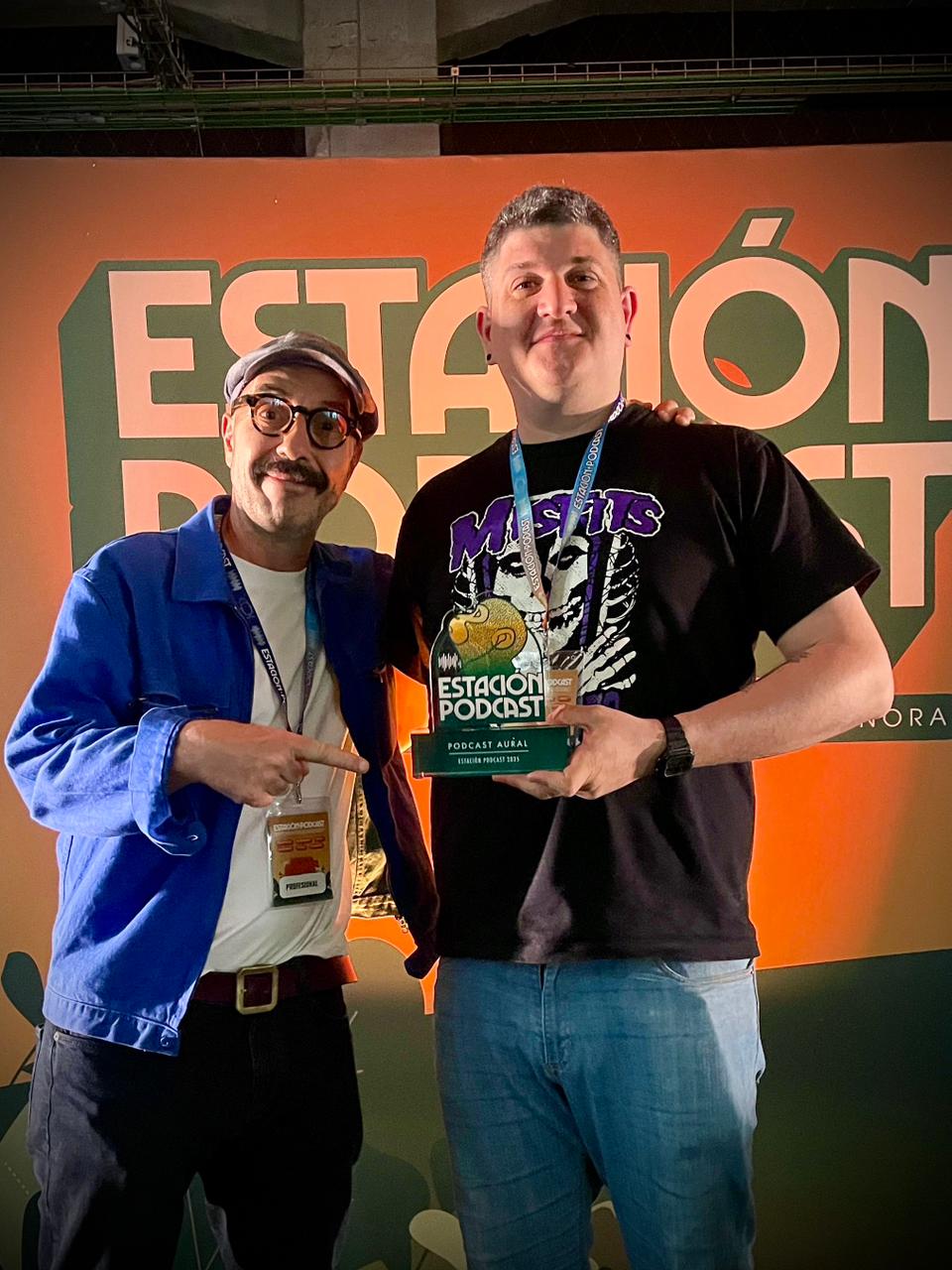 Nicolás Maggi recibe el premio de manos de Carlos Galán, director de Estación Podcast.